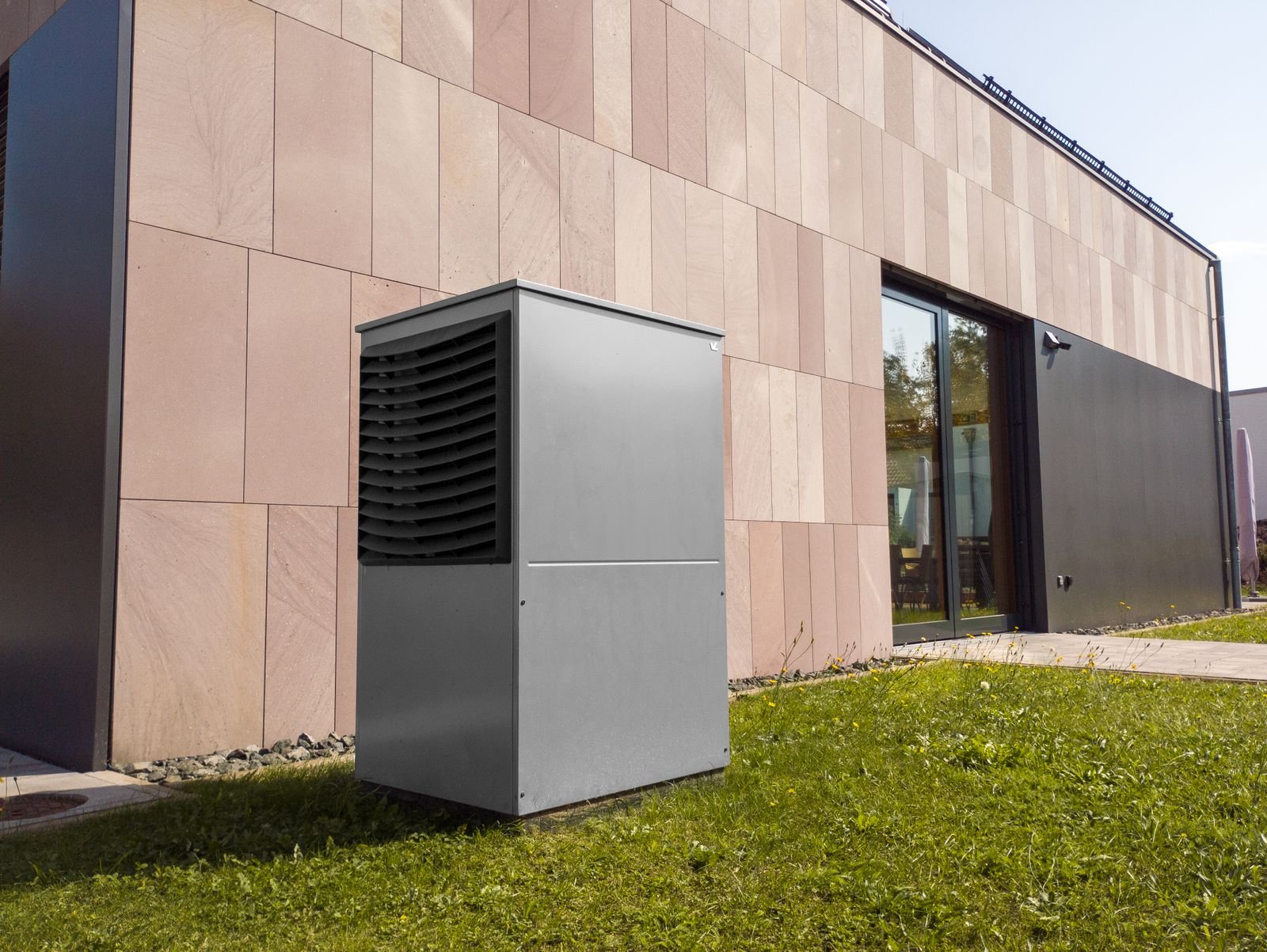 Wärmepumpe vor einem modernen Neubau